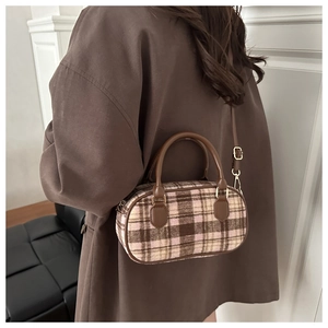 Detail of Boston-style plaid bag with leather handles and gold-tone metal hardware