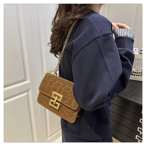 Detail of leopard print suede shoulder bag with gold chain strap and interlocking buckle