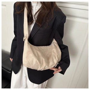 Vue détaillée du sac demi-lune en velours côtelé beige avec texture fine et bandoulière