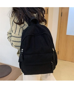 Detailaufnahme des schwarzen Cord-Rucksacks am Modell zeigt Struktur und Reißverschlüsse