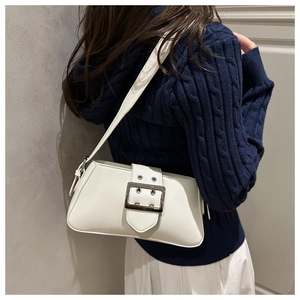 Detail of white leather underarm bag with silver square buckle and adjustable strap