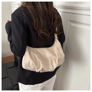 Détail du sac hobo plissé beige clair avec texture suédée douce et nœud latéral