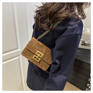 Detail of leopard print crossbody bag with gold chain strap and geometric metal buckle