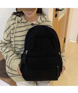 Detailansicht des schwarzen Cord-Rucksacks mit gewebtem Reißverschluss und weicher Textur