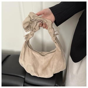 Détail du sac hobo plissé beige avec poignée froncée et nœud décoratif en daim doux