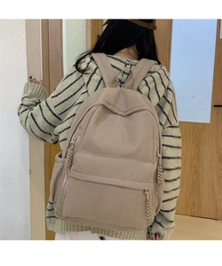 Detail des beigen Cord-Rucksacks mit vertikaler Rippenstruktur und gewebtem Reißverschluss