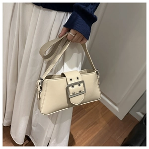 Détail du sac baguette beige montrant la boucle argentée et le cuir synthétique fin