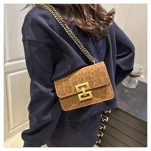 Detail of leopard print crossbody bag with golden chain strap and large metal buckle