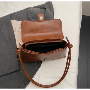 Vue détaillée du sac à bandoulière en cuir marron avec compartiments et poche zippée