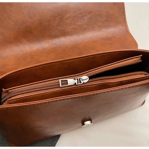 Détail du sac baguette marron caramel avec compartiment zippé et fermoir magnétique argenté