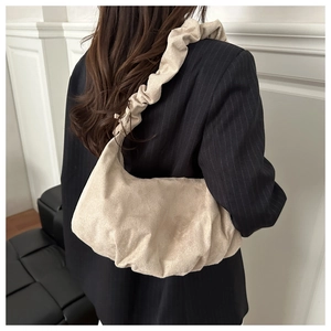 Détail du sac à main plissé beige montrant la texture velours et la bandoulière