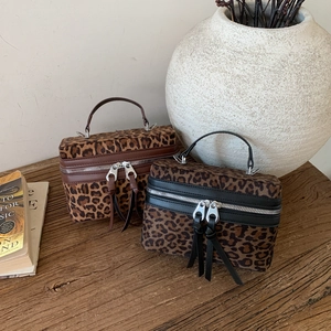 Mini sacs boîtes vintage à motif léopard avec détails argentés sur table bois