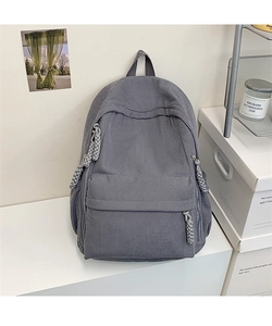 Detailansicht grauer Cord-Rucksack mit Reißverschlusstasche vorne und gewebten Knoten