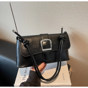 Détail du sac bandoulière en similicuir mat noir avec boucle argentée et bandoulière nouée