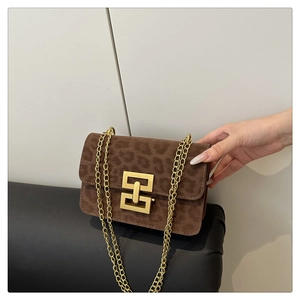 Detail of vintage leopard print crossbody bag with golden geometric clasp and chain strap