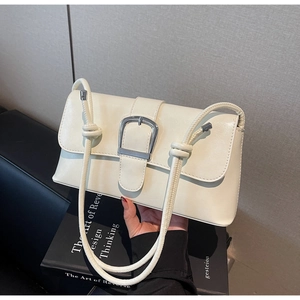 Détail du sac baguette en similicuir blanc crème avec grande boucle et bandoulière nouée