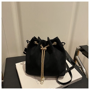 Detail of black frosted bucket bag featuring gold chain drawstring and pearl accents