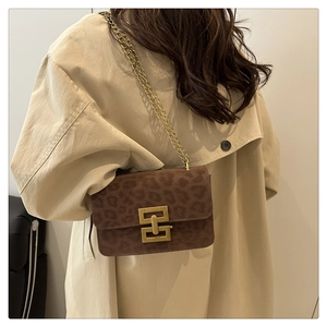 Detail view of leopard print square bag with gold chain and vintage metal buckle closure