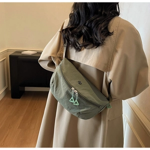 Close-up of army green nylon crescent bag showing brand logo and zipper detail