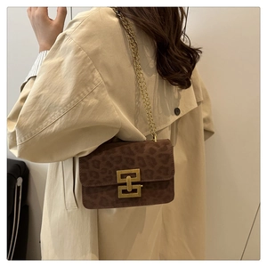 Brown leopard print crossbody bag detail on model wearing a classic beige trench coat