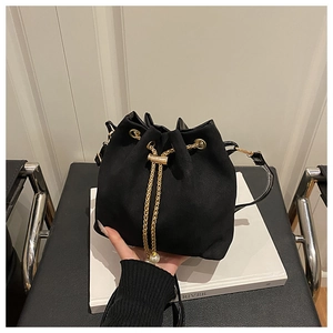 Detail of black suede drawstring bucket bag with gold chain and large pearl ornament