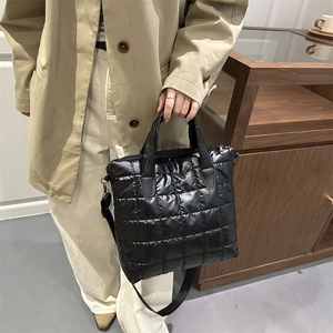 Sac fourre-tout matelassé noir avec finition brillante et bandoulière pour le quotidien