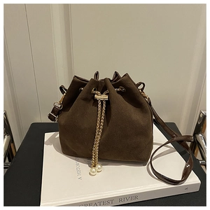 Deep brown suede bucket bag featuring drawstring closure with gold chain and pearl charms