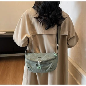 Detail of dark green crescent nylon crossbody bag with adjustable wide strap and zipper