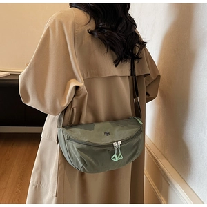Détail du sac croissant en nylon vert avec bandoulière réglable et tirette triangle