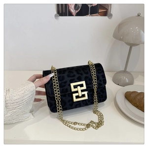Close-up of black leopard print crossbody bag with gold chain and metal lock