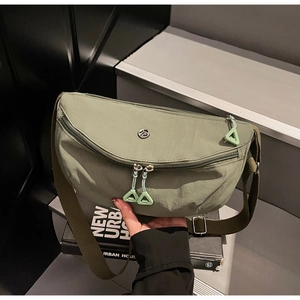 Detail of olive green nylon crescent bag featuring unique green triangular zipper puller