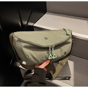 Close-up of olive green nylon crossbody bag showing the durable fabric texture and zipper