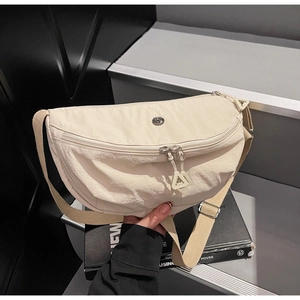 Detail of beige nylon crescent bag with double zipper pockets and adjustable canvas strap