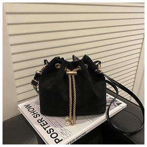 Detail of black suede bucket bag with gold chain drawstring and white pearl accents