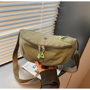 Detail of army green nylon crossbody bag with double zippers and triangle pullers