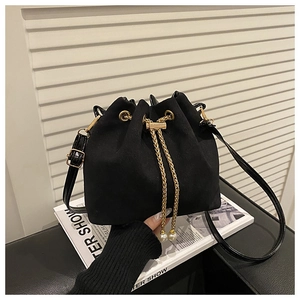 Detail of black matte bucket bag with gold chain drawstring and pearl pendant charms