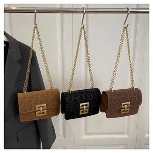 Detailed view of three leopard print crossbody bags with gold chain straps in various colors