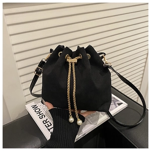 Detail of black suede bucket bag with gold chain drawstring and pearl charms