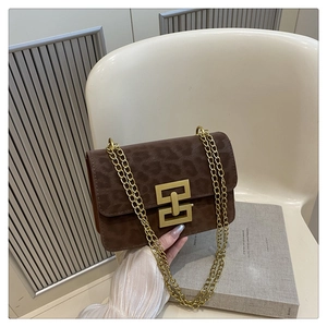 Close-up of leopard print crossbody bag with gold chain strap and geometric metal lock