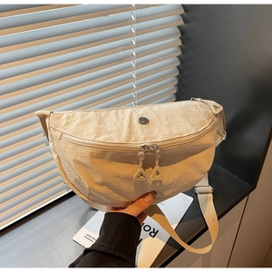 Detailed close-up of beige nylon crescent bag with double zippers and metal logo
