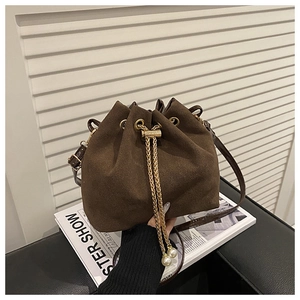 Detail of dark brown matte bucket bag with gold chain drawstring and pearl charms