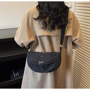 Dettaglio della borsa a mezzaluna in nylon nero indossata sulla schiena con tracolla regolabile