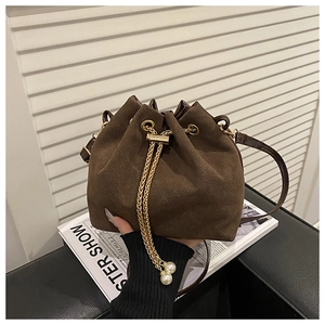 Detail of dark brown matte bucket bag with gold chain drawstring and pearl charm