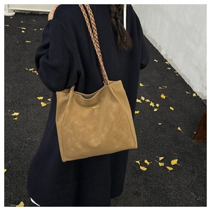 Detail of warm khaki frosted tote bag with braided handle and gold logo text