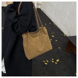 Khaki Tragetasche mit geflochtenem Riemen in einer herbstlichen Straßenszene gezeigt