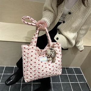 Pink quilted tote bag with red hearts and plush cat charm on shoulder strap