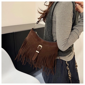 Detail of dark brown suede shoulder bag with dense fringe and vintage buckle strap