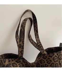 Détail des longues bandoulières lisses d'un sac cabas en toile à imprimé léopard