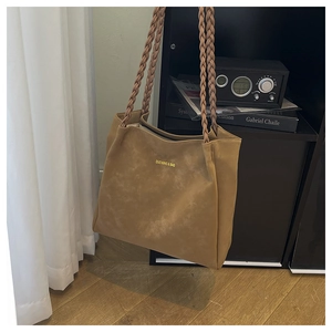 Detail of the woven braided shoulder straps on this large vintage caramel tote bag