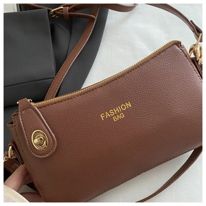 Close-up of brown litchi pattern leather texture and golden hardware on shoulder bag
